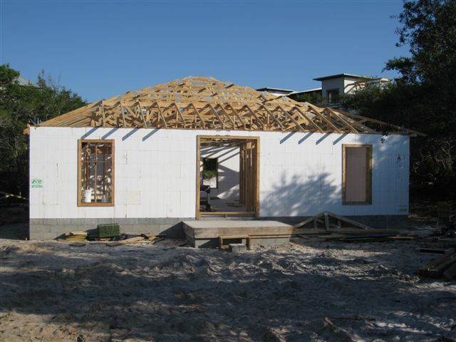House shell of white ICF walls with roof framing started