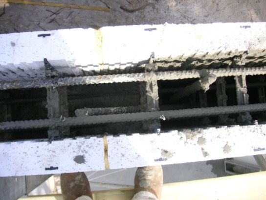 Top of an ICF wall showing foam on both sides, plastic ties, rebar, and concrete in the center