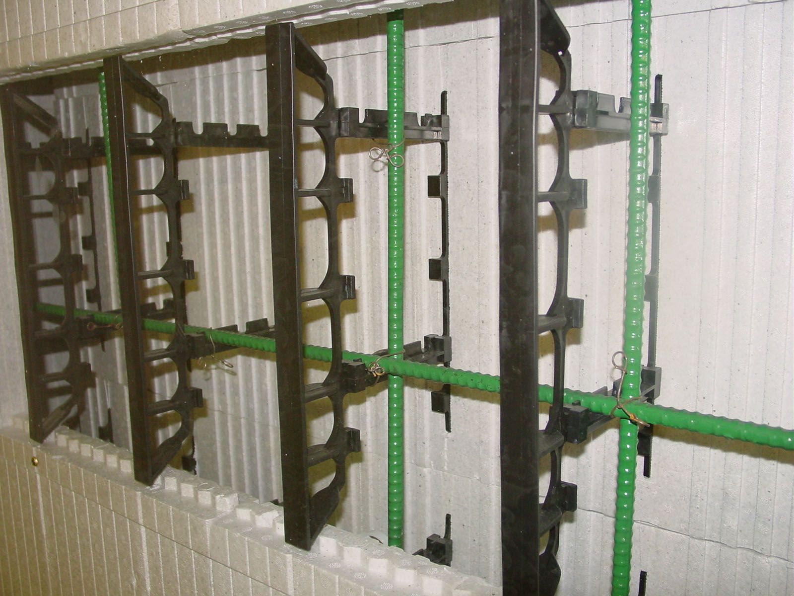 ICF wall opened to show foam faces, plastic ties, and green rebar